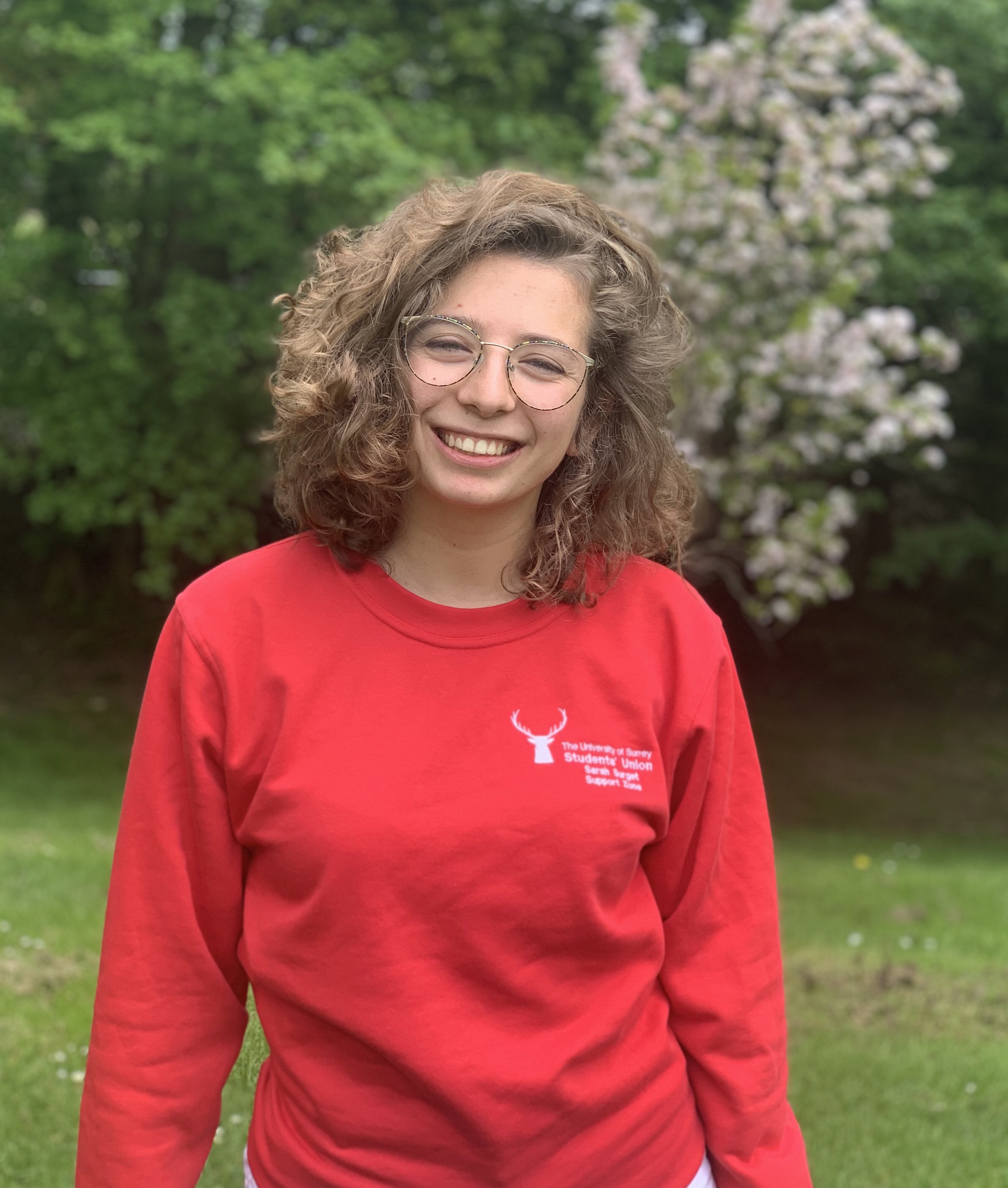Sarah standing outside with trees in background